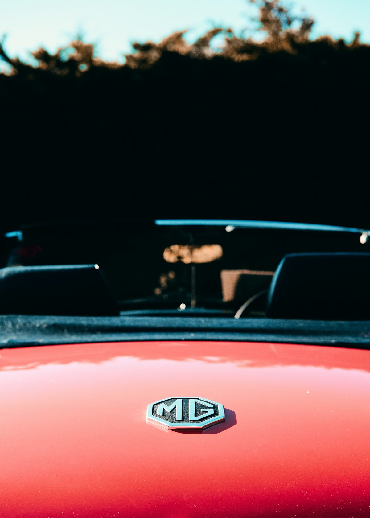 man in black jacket driving red car