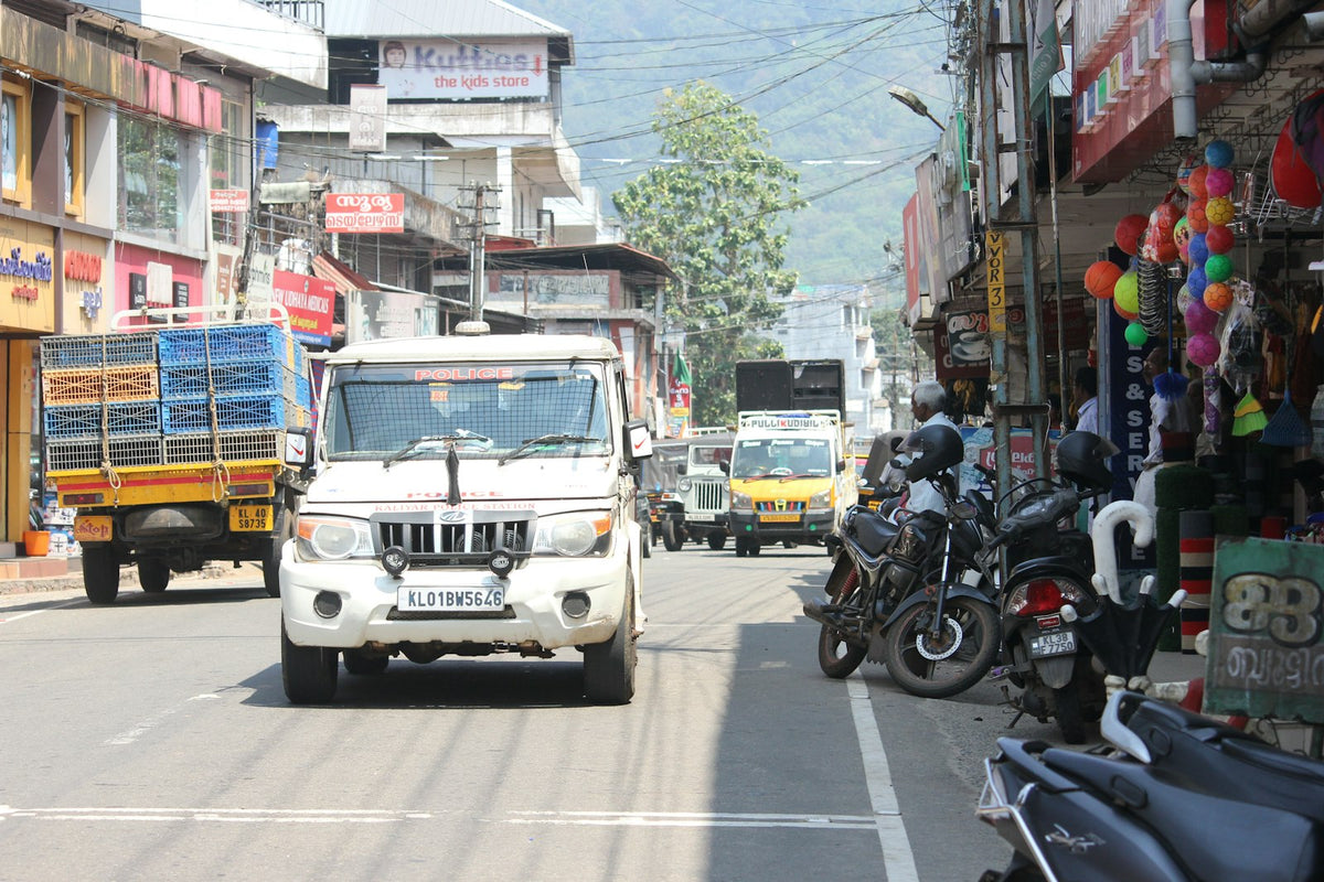 a truck driving down a street next to a motorcycle