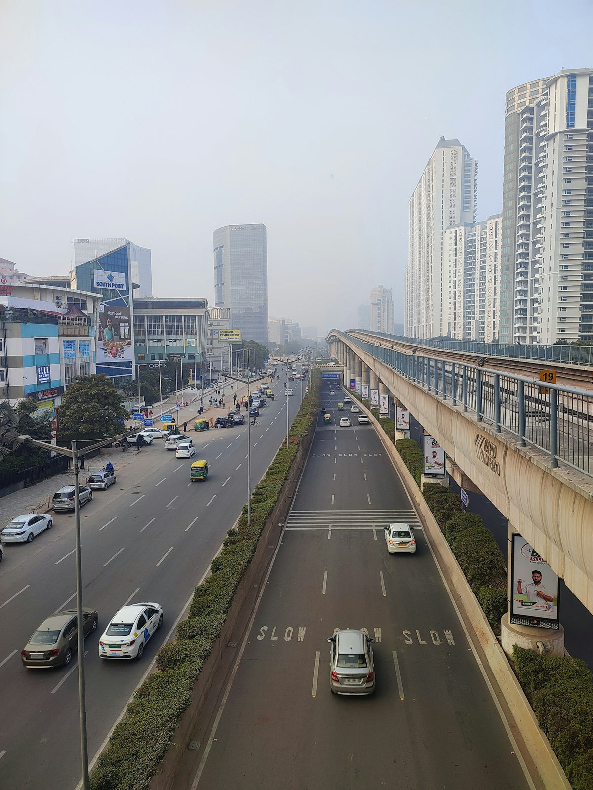 a city street filled with lots of traffic next to tall buildings